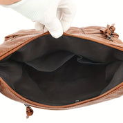 Borsa a tracolla in pelle marrone aperta, interno spazioso con fodera nera, chiusura a zip, design elegante e pratico per uso quotidiano.