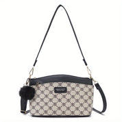 Borsa a tracolla elegante in tessuto beige con motivo geometrico, dettagli in pelle nera, pompon decorativo e tracolla regolabile.