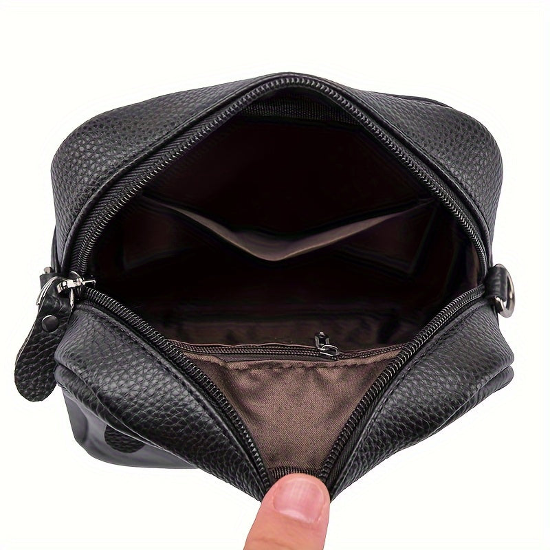 Borsello da uomo in pelle nera aperto, con scomparti interni visibili. Elegante e pratico, ideale per viaggi e uso quotidiano.