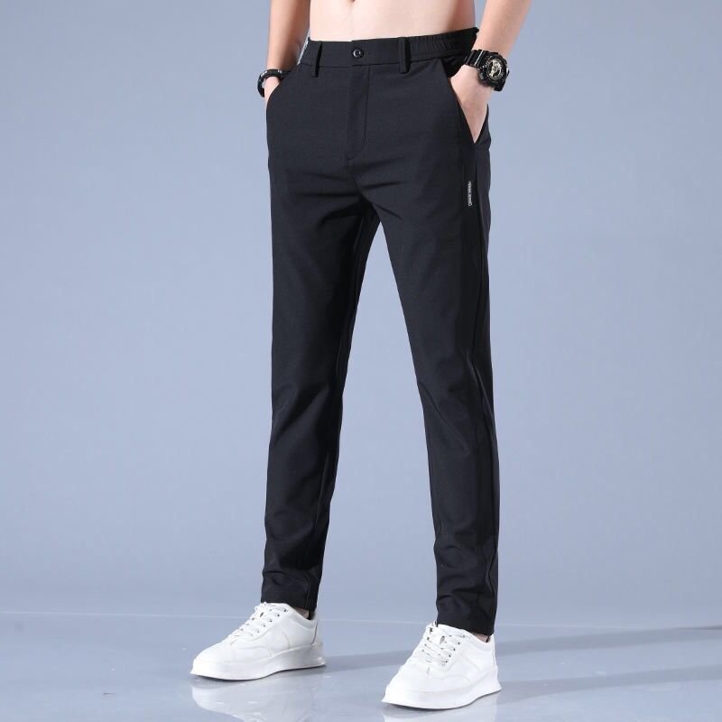 Pantaloni uomo neri eleganti, vestibilità slim, tasche laterali, abbinati a scarpe bianche. Ideali per look casual e formali.