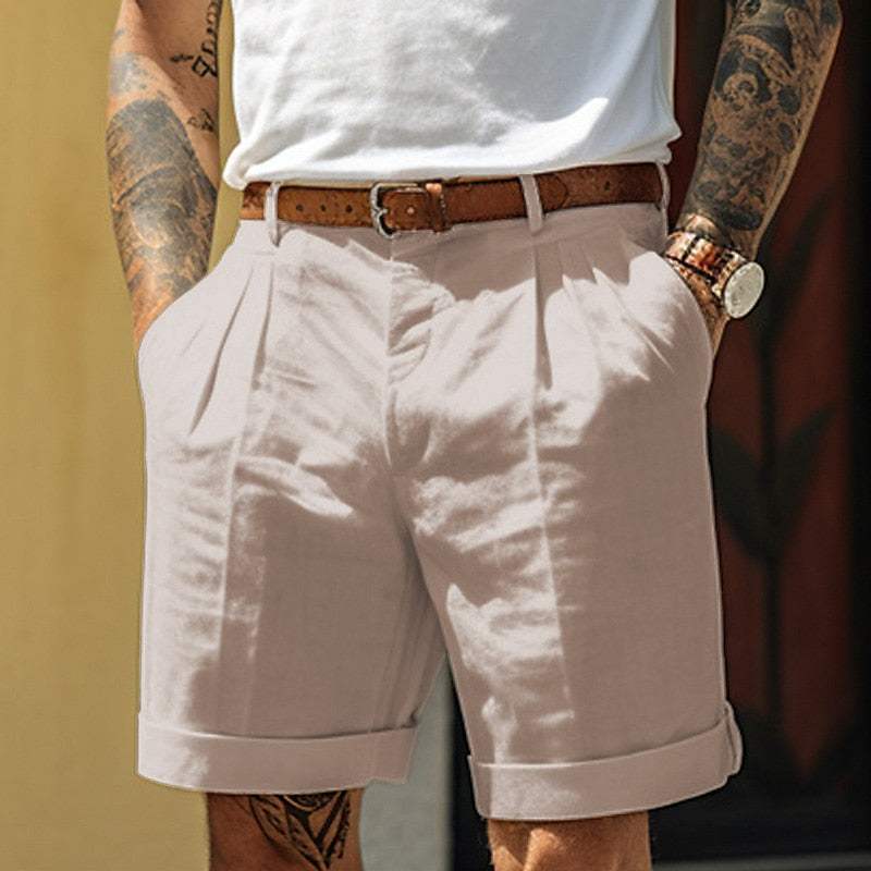 Shorts beige da uomo eleganti, con cintura in pelle marrone, indossati con t-shirt bianca. Stile casual estivo, moda maschile trendy.