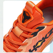 Scarpa sportiva arancione con logo nero, design moderno e dettagli in mesh traspirante. Ideale per attività sportive e tempo libero.