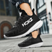 Scarpe da corsa nere HOKZ su strada urbana, design leggero e suola ammortizzata, ideali per jogging e attività sportive all'aperto.