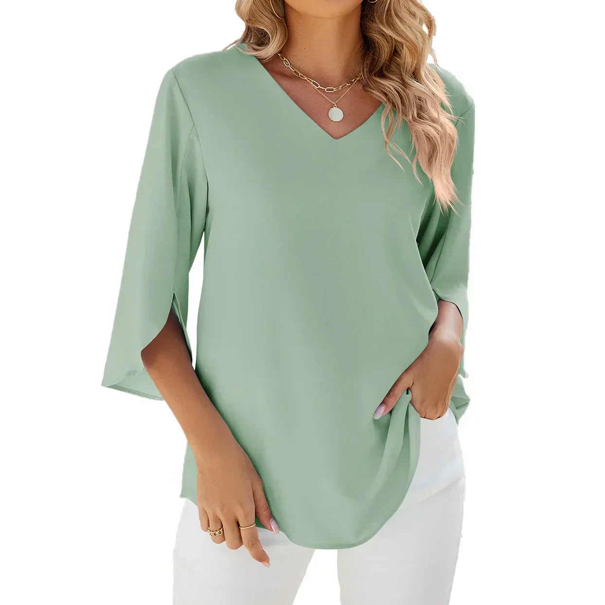 Blusa verde menta da donna con scollo a V, maniche a 3/4, abbinata a pantaloni bianchi. Stile casual elegante, perfetta per la moda estiva.