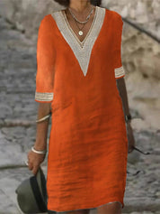 Abito estivo arancione con scollo a V e dettagli in pizzo bianco, maniche a tre quarti, perfetto per moda casual donna.