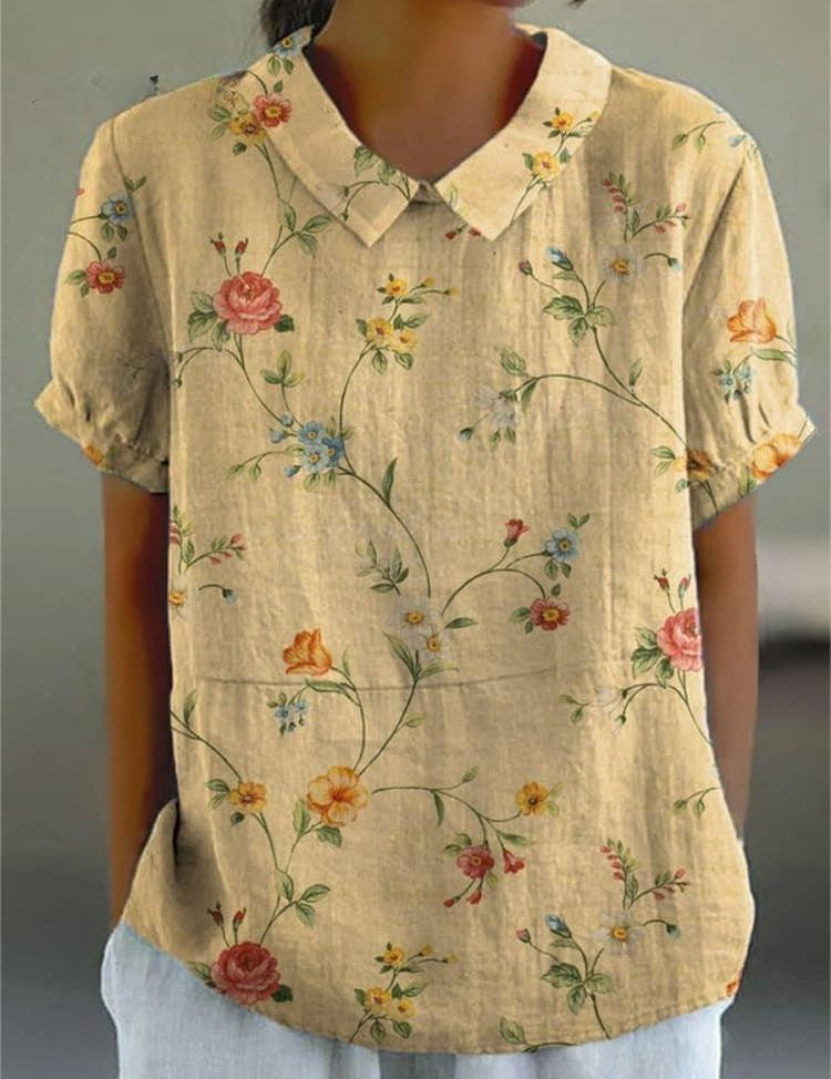 Camicia donna in lino beige con colletto, maniche corte e stampa floreale colorata. Moda estiva casual, abbigliamento leggero e traspirante.