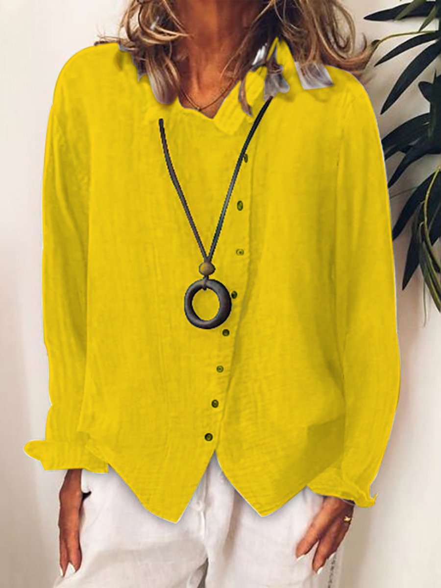 Camicia donna gialla in lino, maniche lunghe, abbinata a collana nera con ciondolo rotondo. Look casual estivo, moda femminile elegante.