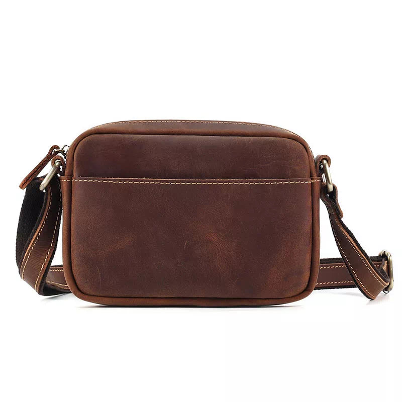 Borsa a tracolla in pelle marrone, design vintage, con cuciture bianche e tracolla regolabile. Accessorio moda uomo/donna elegante e pratico.