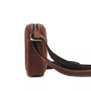 Borsa a tracolla in pelle marrone, vista laterale, con cerniera e tracolla regolabile. Design elegante e compatto per uomo e donna.