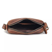 Borsa a tracolla in pelle marrone con cerniera aperta, design elegante e compatto, ideale per uomo e donna, accessorio moda versatile.