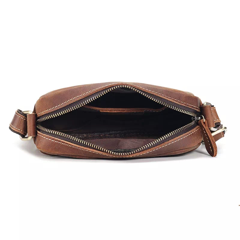 Borsa a tracolla in pelle marrone con cerniera aperta, design elegante e compatto, ideale per uomo e donna, accessorio moda versatile.