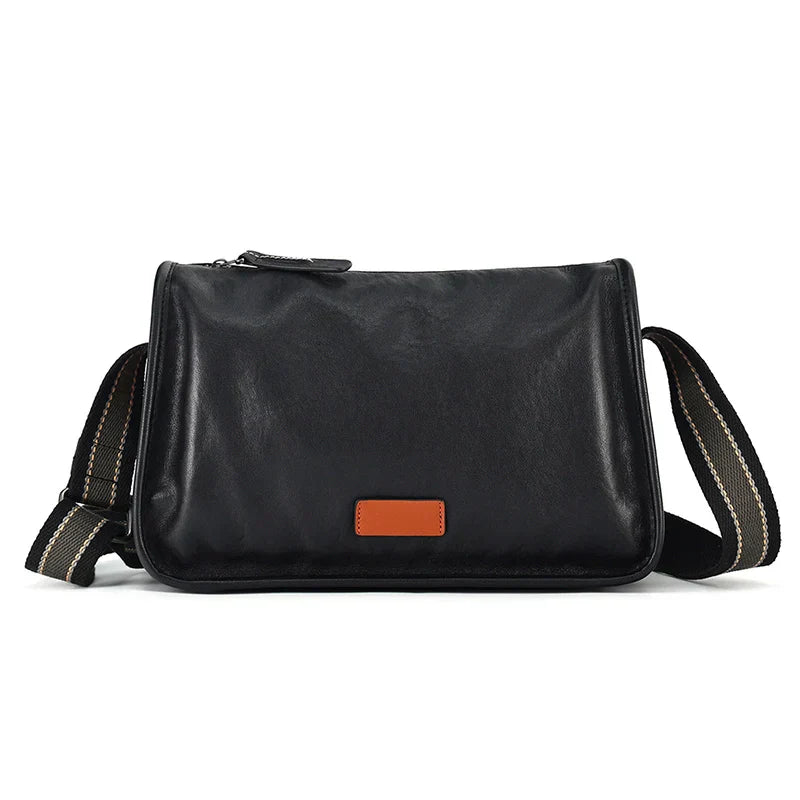 Borsa a tracolla in pelle nera unisex, design elegante con cinghia regolabile e dettaglio marrone. Ideale per lavoro e tempo libero.
