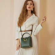 Donna con abito bianco elegante e borsa verde in pelle, posa sofisticata. Moda femminile, accessori di lusso, stile chic.
