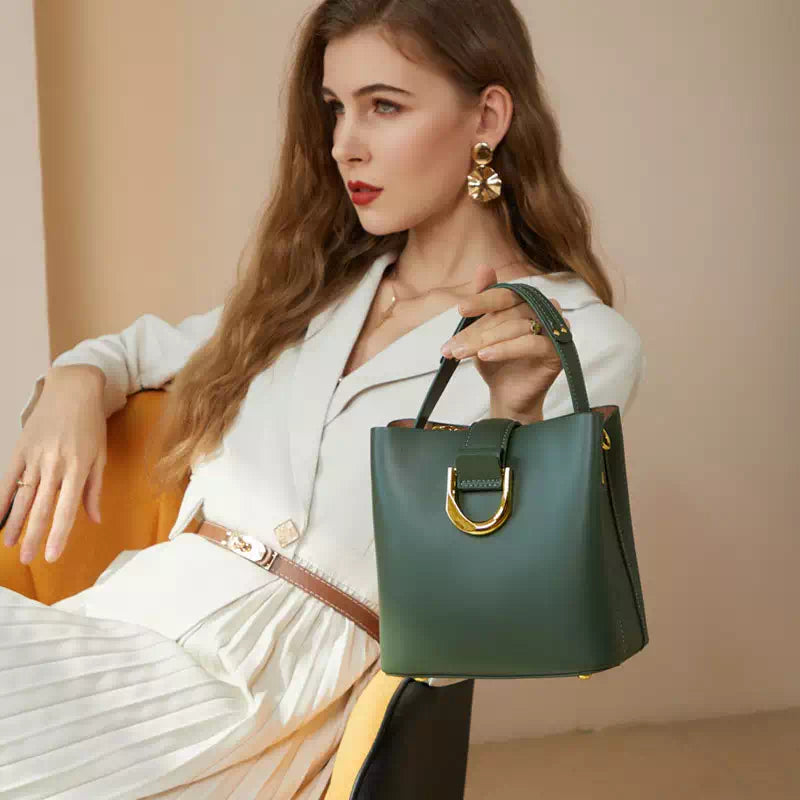 Donna elegante con borsa a mano verde in pelle, abito bianco, orecchini dorati. Moda femminile, accessori di lusso, stile sofisticato.