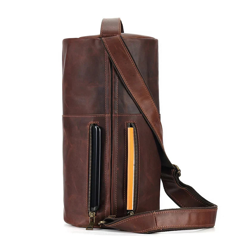 Borsa a tracolla in pelle marrone, design cilindrico, con tasche con cerniera. Elegante e versatile per uomo e donna. Accessorio moda di qualità.