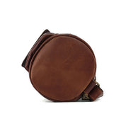 Borsa a tracolla in pelle marrone, design rotondo, chiusura con fibbia, stile vintage, ideale per uomo e donna, accessorio moda elegante.