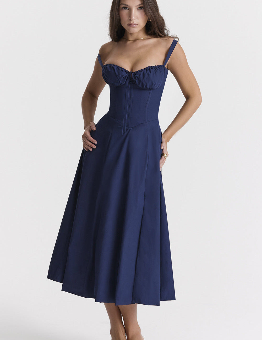 Abito lungo blu scuro elegante con spalline sottili e corpetto aderente, perfetto per eventi serali. Modello femminile in posa.
