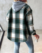 Giacca a quadri verde e bianca con cappuccio grigio, indossata da una persona di spalle. Moda casual autunnale, stile urbano.