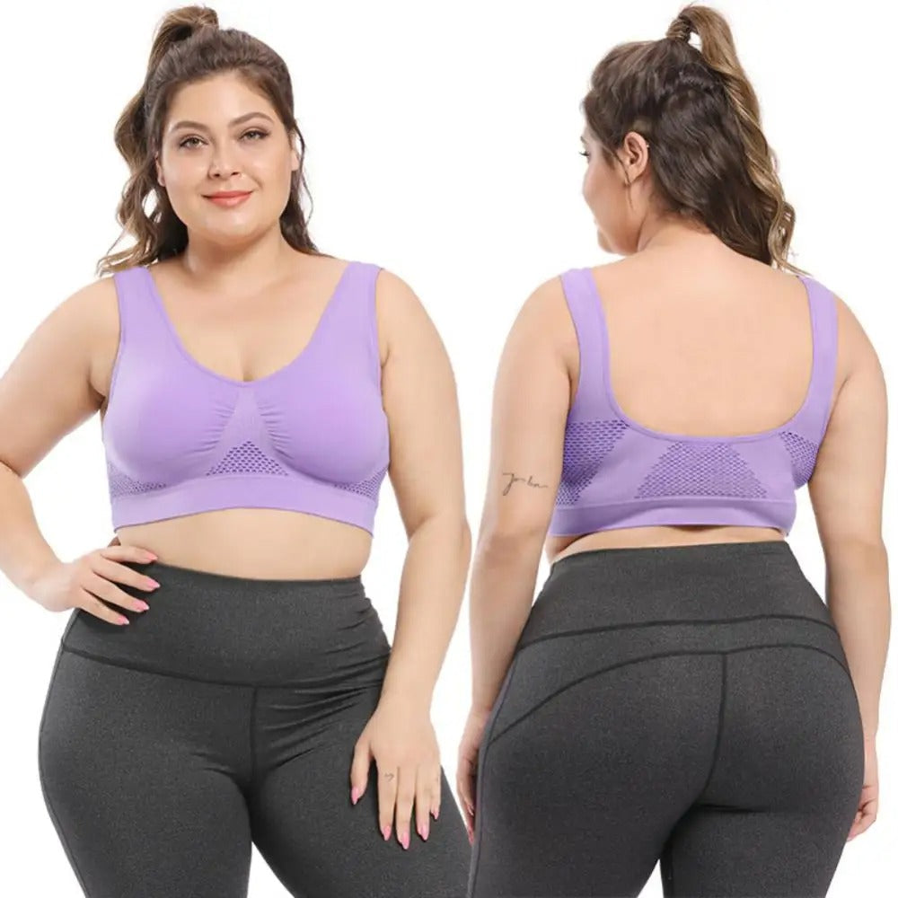 Donna in abbigliamento sportivo: reggiseno sportivo viola, leggings grigi. Abbigliamento fitness taglie forti, comodo e traspirante.