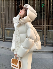 Donna con giacca piumino bianco, cappuccio, cappello marrone, borsa in pelliccia sintetica. Moda invernale urbana, abbigliamento caldo elegante.