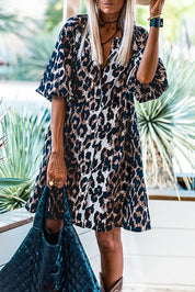 Abito donna a maniche corte con stampa leopardata, accessoriato con borsa trapuntata blu. Look casual chic, moda femminile trendy.