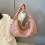 Borsa a spalla intrecciata in pelle rosa tenue, design elegante e moderno, perfetta per moda femminile, accessorio di tendenza 2023.