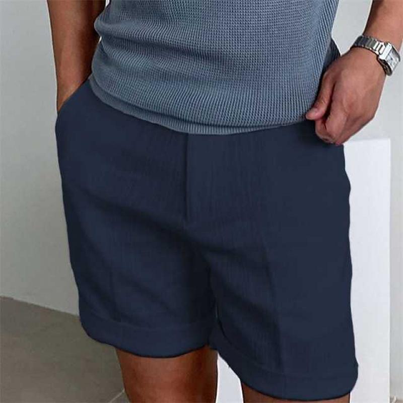Pantaloncini uomo blu scuro, tessuto leggero, tasche laterali, indossati con maglietta grigia. Ideali per moda estiva casual.