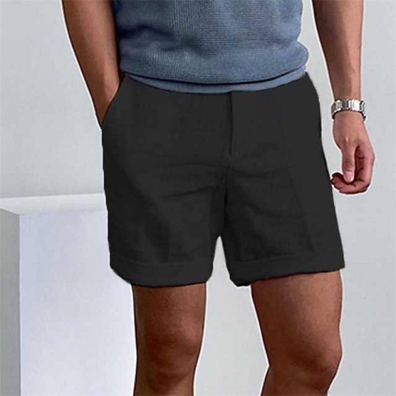 Uomo in pantaloncini neri casual, maglietta grigia, orologio al polso. Moda estiva maschile, abbigliamento comodo, stile urbano.