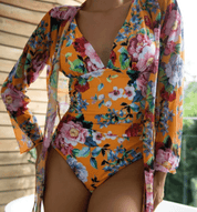 Costume intero donna floreale arancione con copricostume abbinato, design elegante e colorato, perfetto per l'estate e la spiaggia.