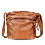 Borsa a tracolla in pelle marrone con doppie tasche frontali e cerniere, design elegante e pratico, ideale per moda donna e accessori casual.