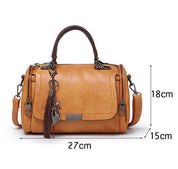 Borsa a mano in pelle marrone chiaro, dimensioni 27x18x15 cm, con tracolla regolabile e ciondolo decorativo. Elegante e versatile per ogni occasione.