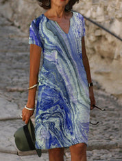 Abito estivo donna, fantasia marmo blu e bianco, scollo a V, maniche corte. Perfetto per look casual eleganti. Moda femminile estiva.