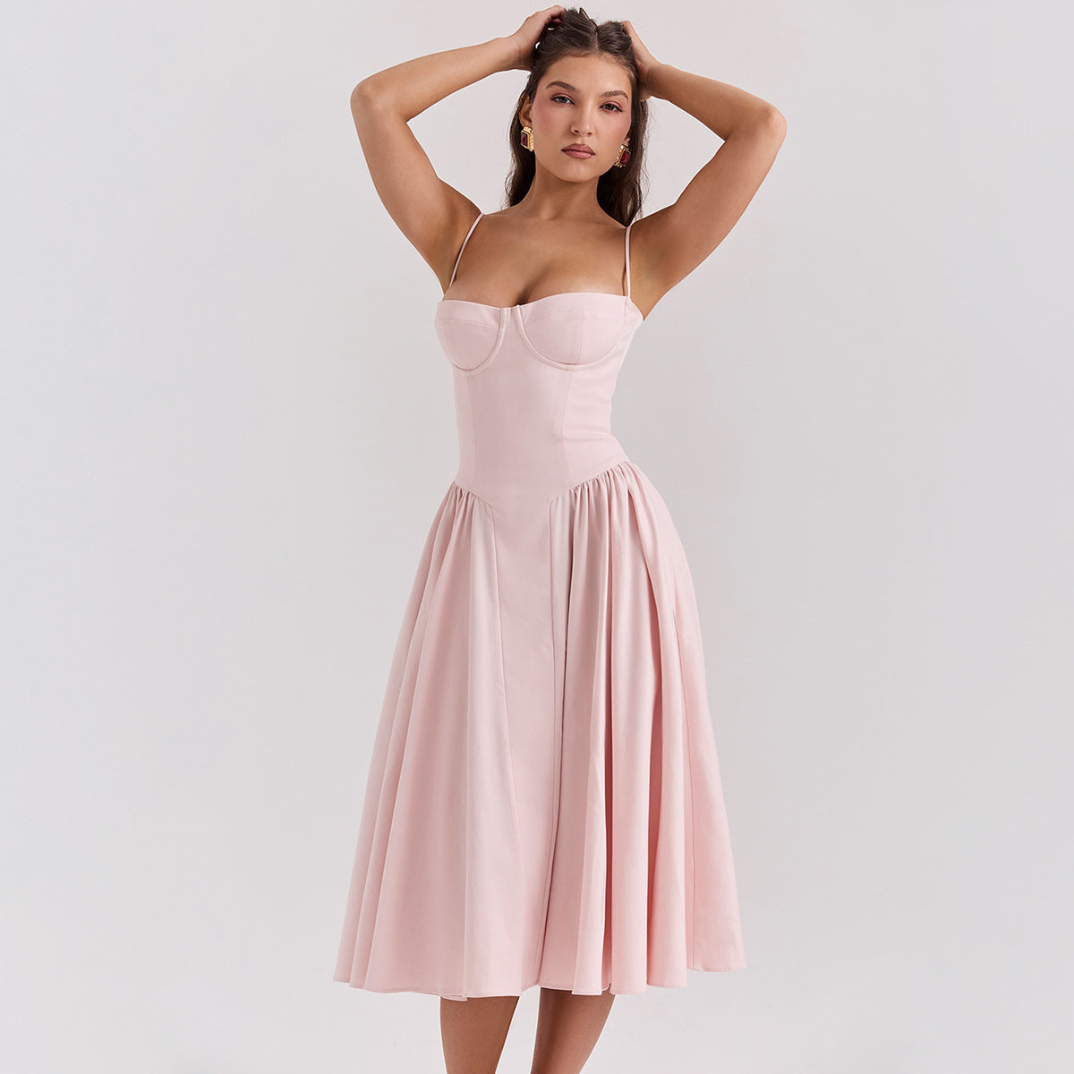 Abito rosa chiaro elegante con spalline sottili e gonna ampia, indossato da una modella. Perfetto per eventi formali e cerimonie.