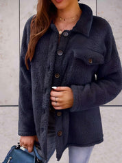 Giacca in pile nero da donna, con bottoni e tasca frontale, indossata su jeans. Moda autunnale, abbigliamento casual elegante.
