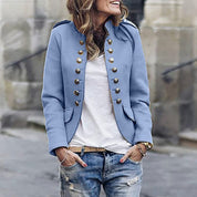 Giacca militare donna blu con bottoni dorati, stile casual chic, abbinata a jeans strappati. Moda autunnale, abbigliamento femminile trendy.