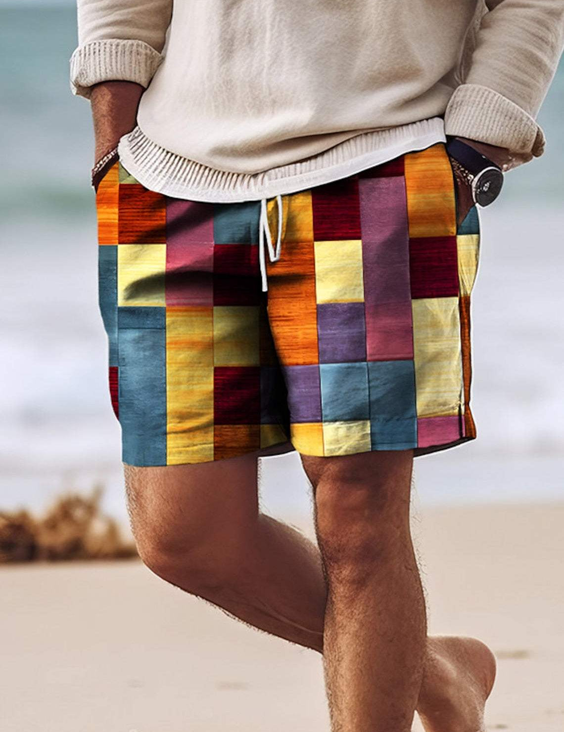 Shorts uomo a quadri colorati, stile casual estivo, indossati su spiaggia. Design vivace, tessuto leggero, ideale per moda mare e vacanze.
