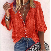 Camicia donna arancione a maniche corte con motivo, abbinata a jeans. Accessori: collane, bracciali, foulard colorato. Stile casual estivo.