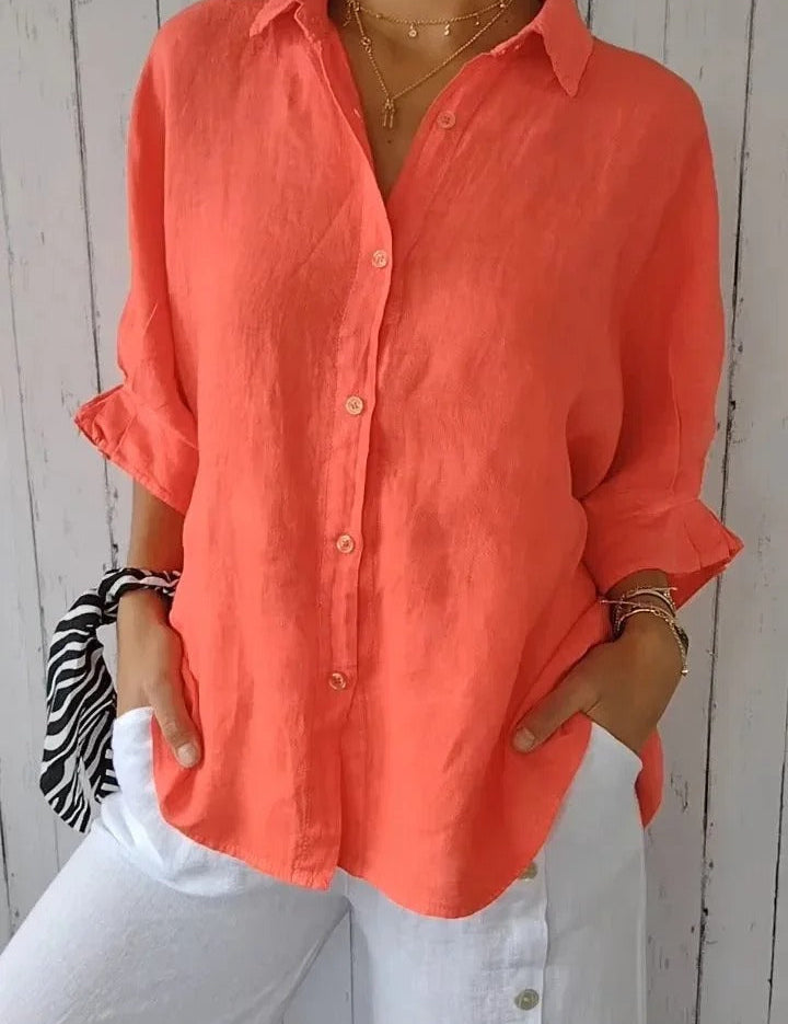 Camicia donna in lino arancione, maniche lunghe, abbinata a pantaloni bianchi. Moda estiva casual, stile elegante e fresco.