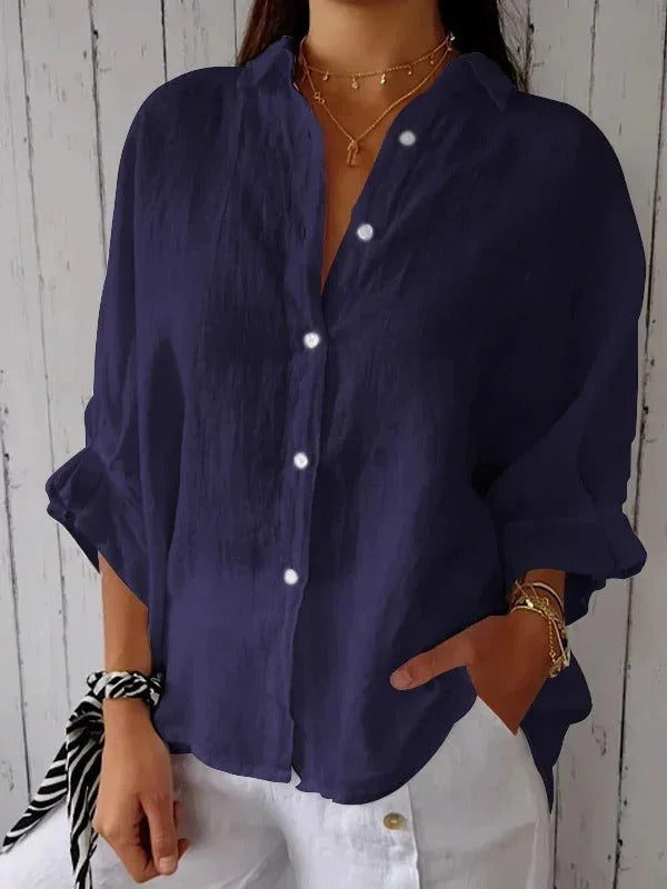Camicia donna blu scuro in lino, maniche lunghe, bottoni bianchi, stile casual, abbinata a pantaloni bianchi. Moda estiva elegante.