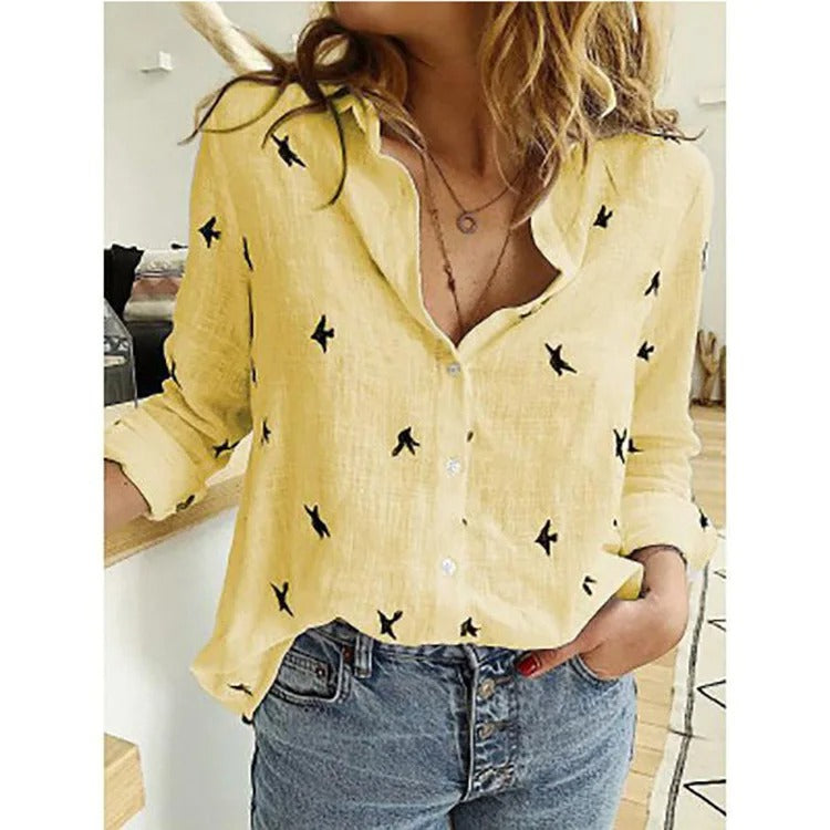 Camicia gialla da donna con motivo a uccelli neri, abbinata a jeans a vita alta. Stile casual, perfetta per la moda primaverile ed estiva.