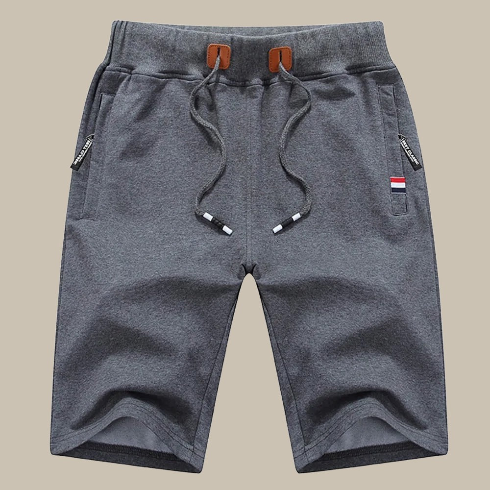 Pantaloncini sportivi grigi da uomo, con coulisse e tasche laterali, design casual, tessuto morbido, ideali per attività all'aperto e tempo libero.
