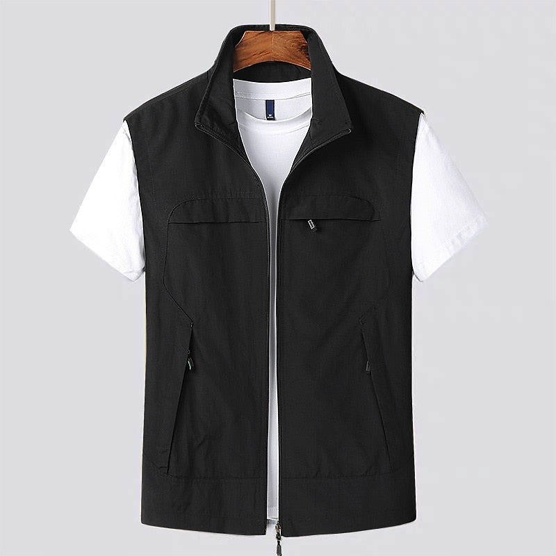 Gilet nero da uomo con cerniera, senza maniche, su gruccia. Indossato sopra una maglietta bianca. Abbigliamento casual elegante.